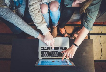 Customer Retention - three person pointing the silver laptop computer