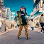 Trends - woman in green jacket stands and pose on street