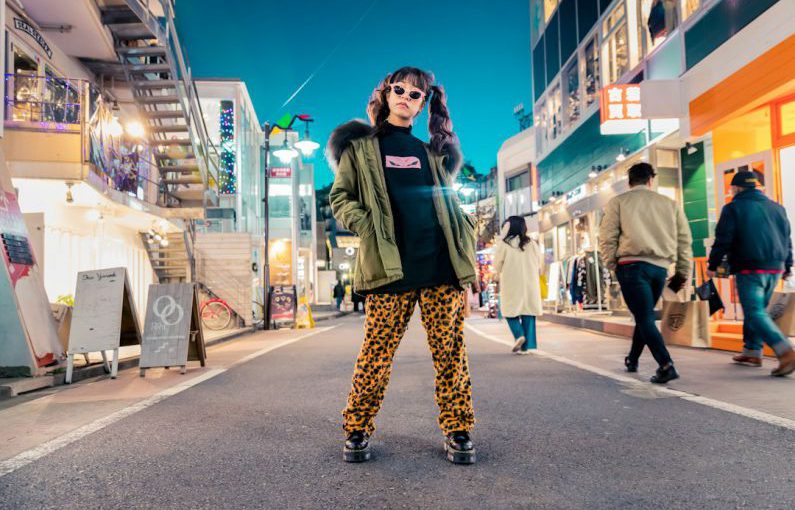 Trends - woman in green jacket stands and pose on street
