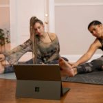 Technology - a couple of women sitting on top of a wooden floor