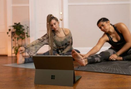 Technology - a couple of women sitting on top of a wooden floor