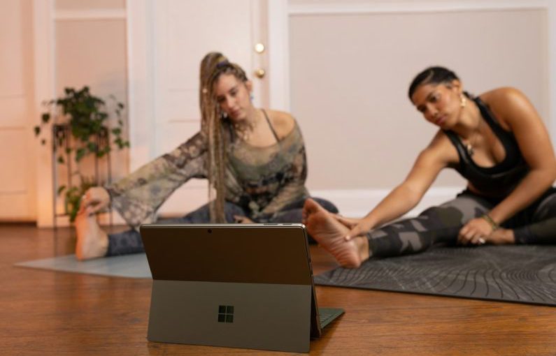 Technology - a couple of women sitting on top of a wooden floor