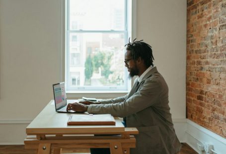 Remote Work - a person sitting at a desk with a laptop and papers