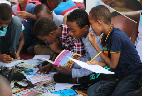Continuous Learning - boy in blue and white plaid shirt reading book