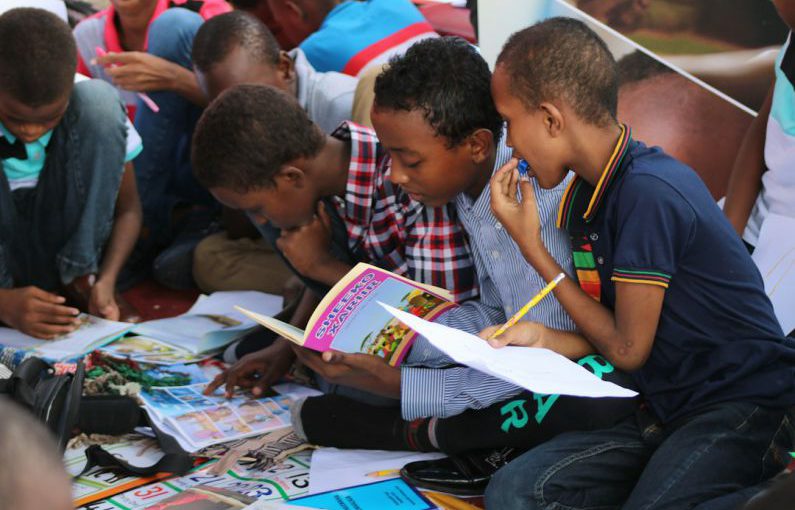 Continuous Learning - boy in blue and white plaid shirt reading book