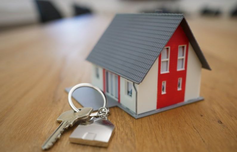 Home Buying - white and red wooden house miniature on brown table