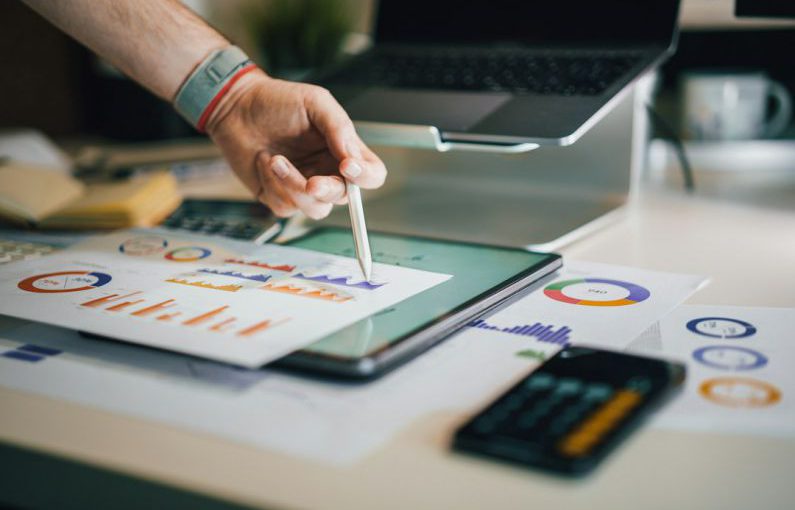 Tax Impact - a person is writing on a piece of paper