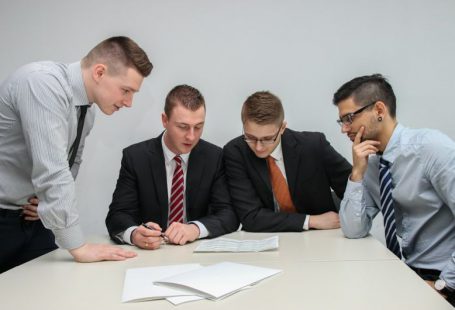 Financial Discussion - four men looking to the paper on table