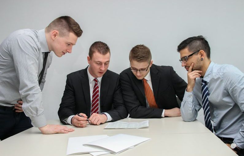 Financial Discussion - four men looking to the paper on table