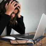 Financial Stress - woman in black long sleeve shirt covering her face with her hands