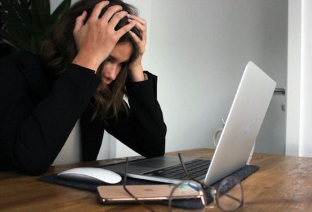 Financial Stress - woman in black long sleeve shirt covering her face with her hands