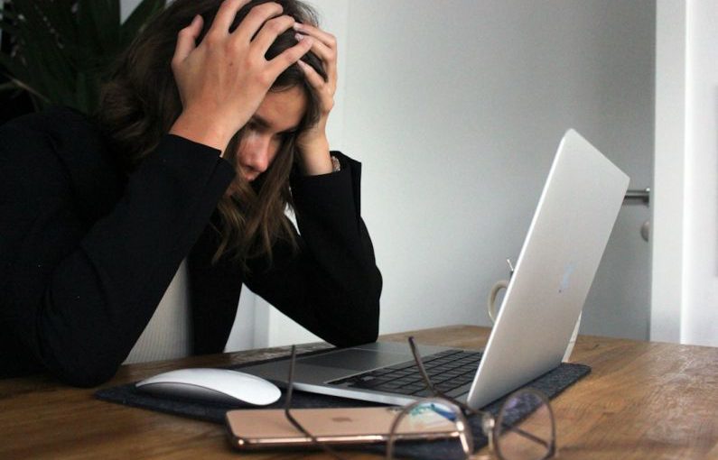 Financial Stress - woman in black long sleeve shirt covering her face with her hands