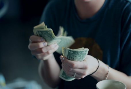 Behavioral Finance - focus photography of person counting dollar banknotes