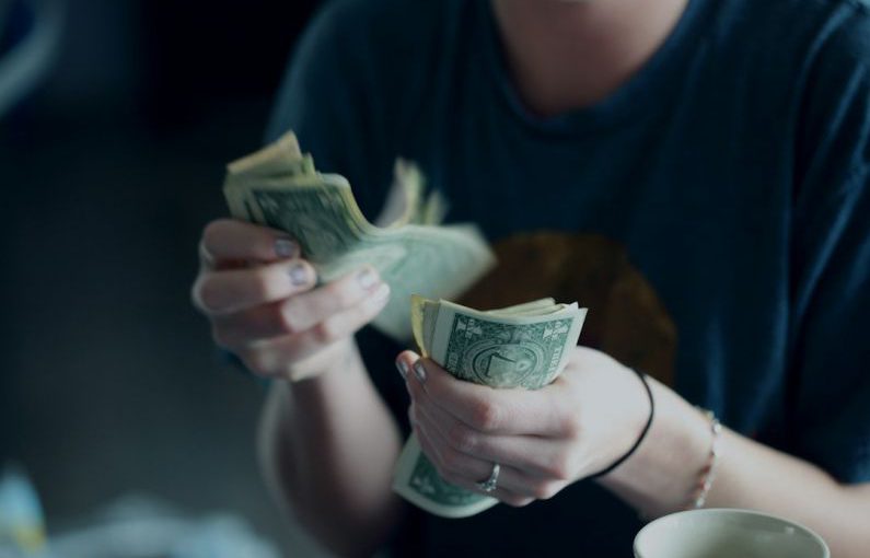 Behavioral Finance - focus photography of person counting dollar banknotes