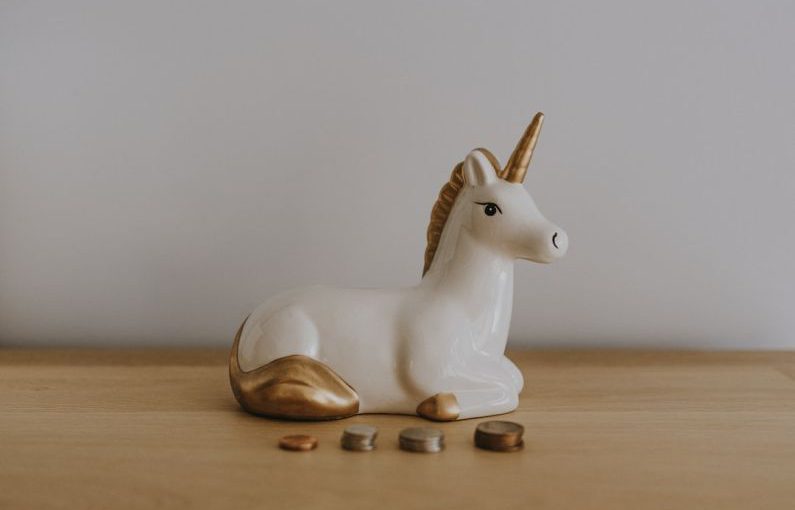 Real Estate Coins - white and gold ceramic unicorn figurine near coins