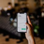 Short-term Investment - person holding black iPhone displaying stock exchange