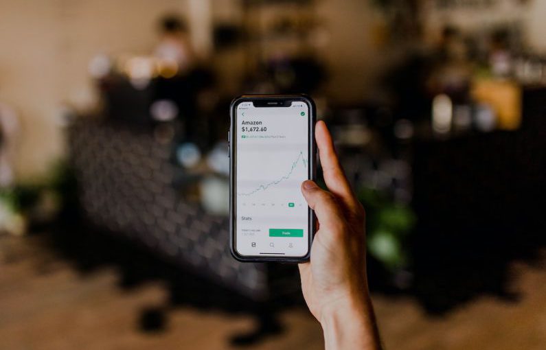 Short-term Investment - person holding black iPhone displaying stock exchange