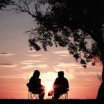 Retirement Planning - silhouette of two person sitting on chair near tree