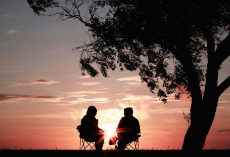 Retirement Planning - silhouette of two person sitting on chair near tree