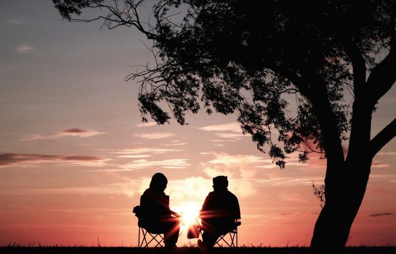 Retirement Planning - silhouette of two person sitting on chair near tree