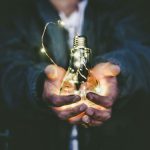 Value Investing - man holding incandescent bulb