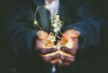 Value Investing - man holding incandescent bulb