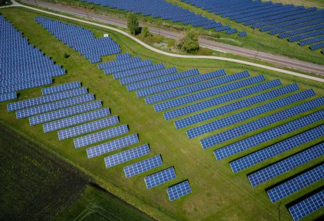 Renewable Energy - aerial photography of grass field with blue solar panels