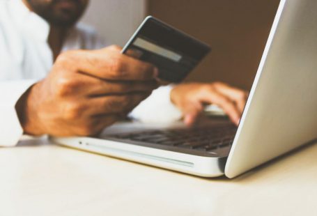 Online Banking - person using laptop computer holding card