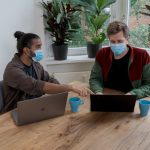 Funding Presentation - man and woman sitting at table using macbook