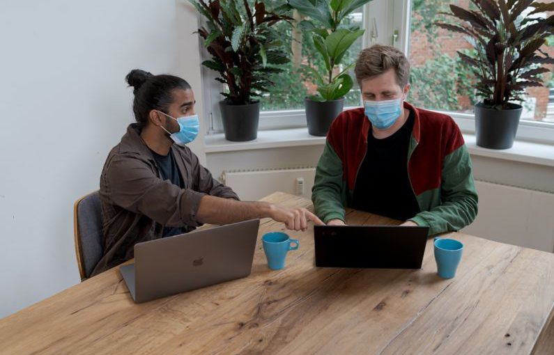 Funding Presentation - man and woman sitting at table using macbook
