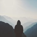 Challenge Mountain - man in hoodie standing in front of the mountain