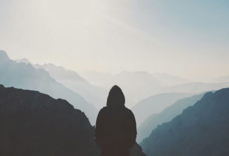 Challenge Mountain - man in hoodie standing in front of the mountain
