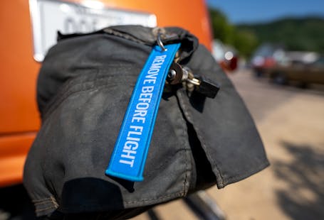 Bright blue 'remove before flight' tag on vehicle exhaust cover.